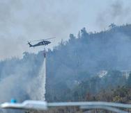Helicóptero de la Guardia Nacional echa agua en el área del fuego forestal en Gurabo.