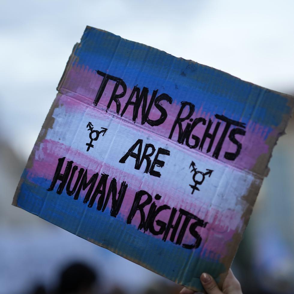 ARCHIVO - Un manifestante alza un cartel en una marcha por los derechos de las personas transgénero en Lisboa el 31 de marzo del 2022. (AP Foto/Armando Franca)