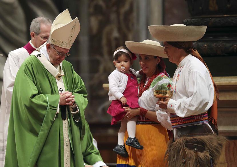 Una familia camina hacia el altar ante el papa Francisco. (AP)