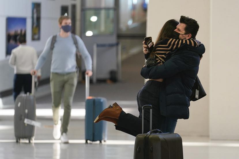 Natalia Abrahao es alzada por su prometido Mark Ogertsehnig mientras ambos se abrazan en el aeropuerto internacional Newark Liberty en Newark, Nueva Jersey.