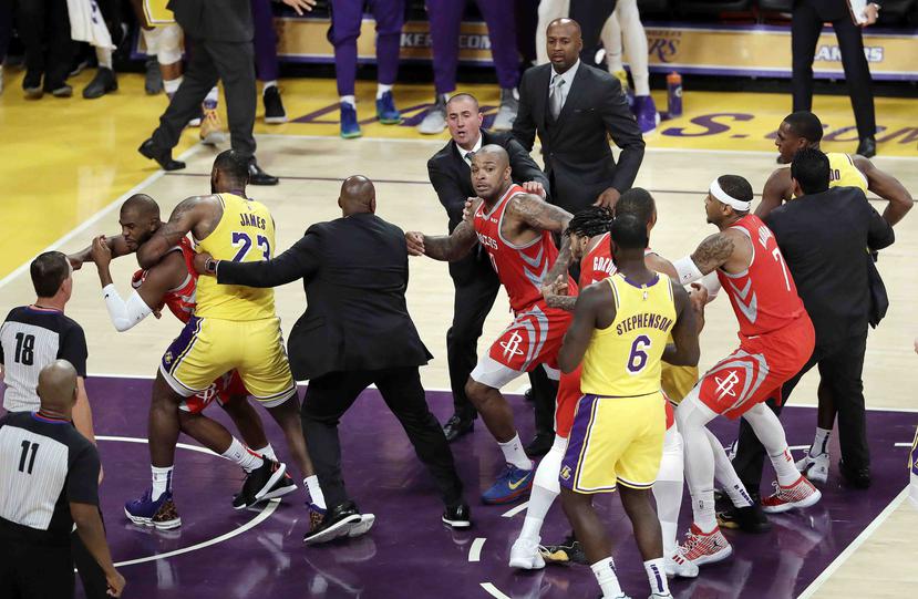 Chris Paul, de los Rockets de Houston, a la izquierda, es sujetado por LeBron James, de Los Lakers de Los Ángeles, después de una pelea con Rajon Rondo, de los Lakers, en la segunda mitad del juego del sábado. (AP / Marcio José Sánchez)