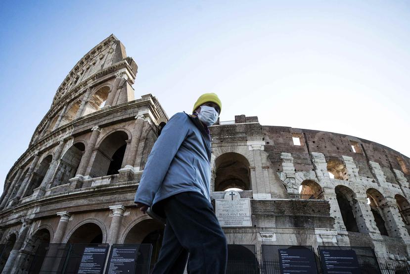Un turista utiliza una mascarilla protectora para mientras visita el coliseo romano. (EFE)
