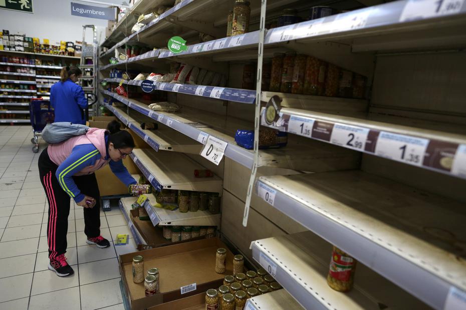 Una compradora sostiene un artículo rodeada de estantes casi vacíos en un supermercado en Madrid, en esta fotografía de archivo del 10 de marzo de 2020. La gente hizo compras de pánico de alimentos y suministros después de que el ministro de Salud de España anunciara un fuerte aumento en los casos de coronavirus en la capital nacional y sus alrededores.