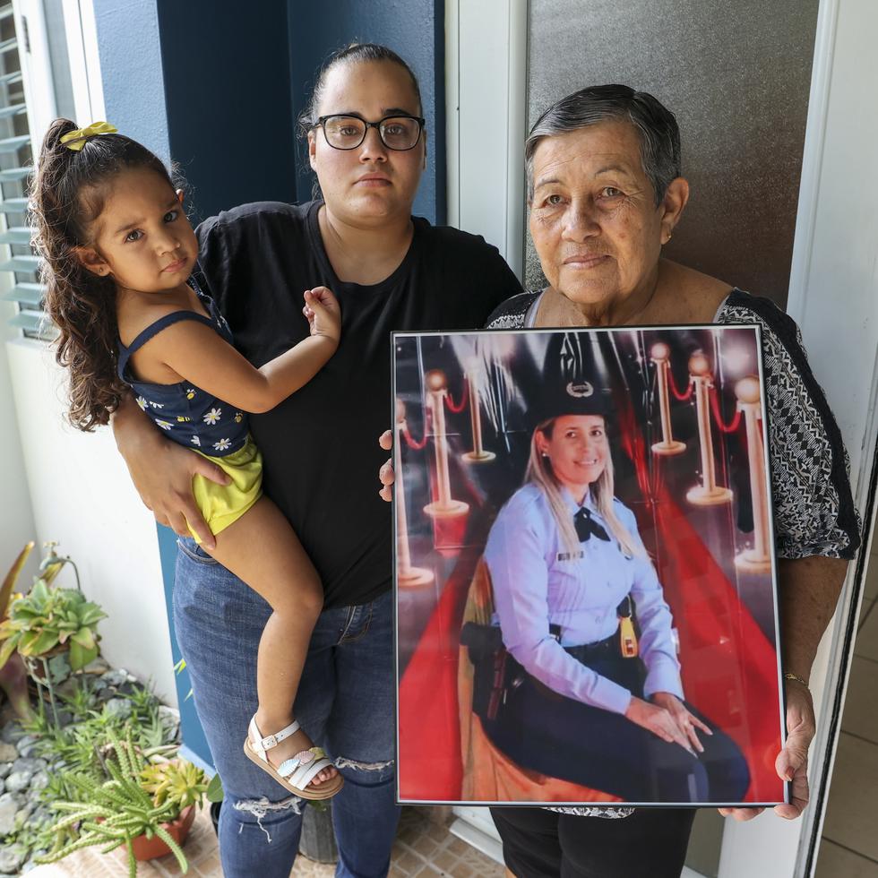 Suleika Bahamonde muestra una foto de su hija, la agente Brenda Pérez Bahamonde. La acompaña la hija de la oficial asesinada, Nicole Colón Pérez, quien carga a su sobrina Lexuanys.
