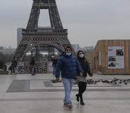 Dos personas, con mascarilla por la pandemia del coronavirus, cruzan la Plaza del Trocadero, en París.