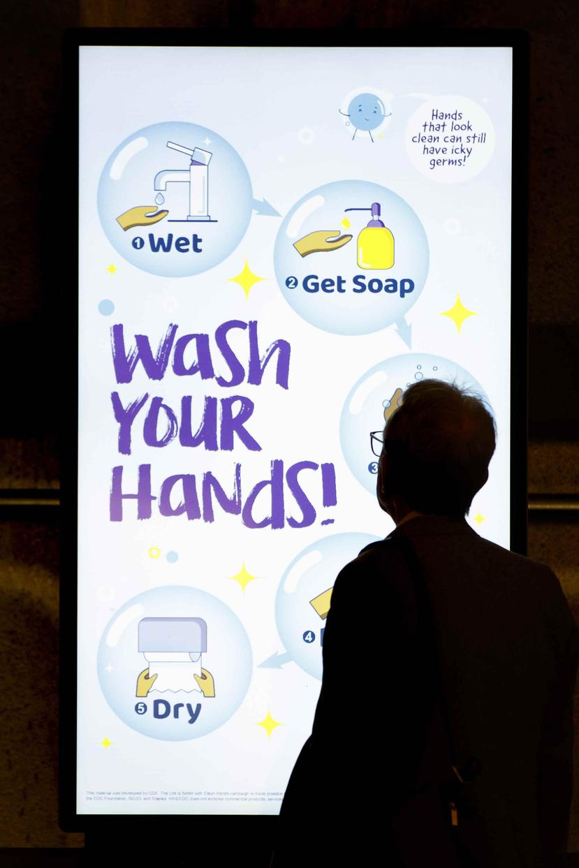 Una persona lee el anuncio de una pantalla en la estación Gallery Place del metro de Washington el viernes 13 de marzo de 2020, que recomienda lavarse las manos para prevenir el contagio de coronavirus. (AP/Carolyn Kaster)