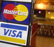 Los logotipos de las tarjetas de crédito MasterCard y Visa a la entrada de una cafetería en Nueva York.