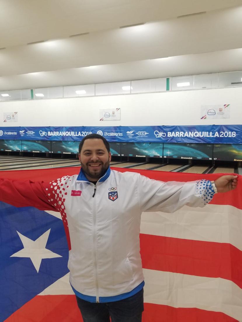 Francisco Valiente  posa con la bandera de Puerto Rico.