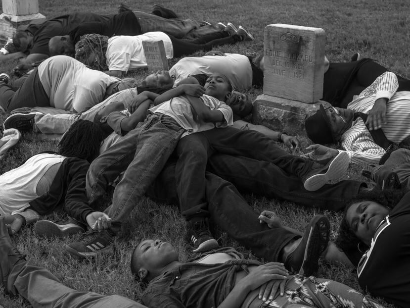 Estudiantes y adultos participan de una manifestación en un cementerio para exigir la exhumación de las víctimas de la masacre.