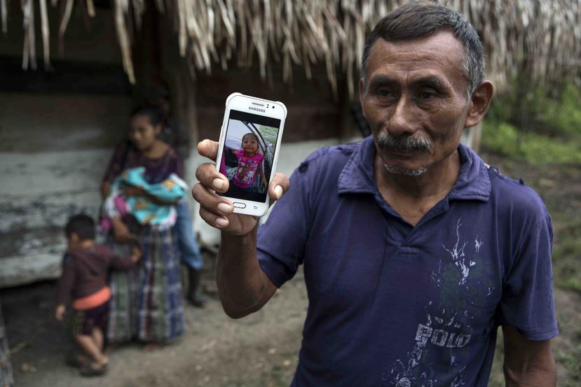 En esta fotografía del 15 de diciembre de 2018, Domingo Caal Chub, de 61 años, sostiene un teléfono en el que muestra una foto de su nieta Jakelin Maquin, en Raxruha, Guatemala. La niña falleció en un hospital de Texas. (AP)