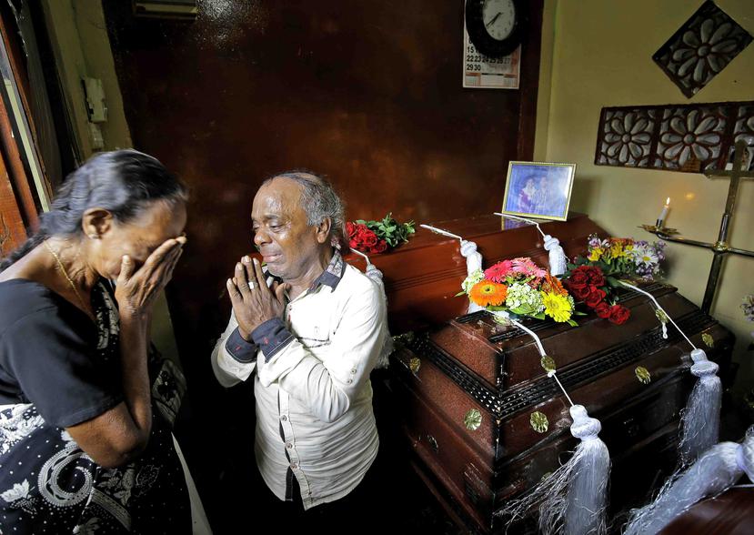 Una familia de Sri Lanka llora junto a los ataudes de tres miembros de su familia, todas fallecidas en los ataques del Domingo de Pascua, en Colombo, Sri Lanka, el 23 de abril de 2019. (AP)