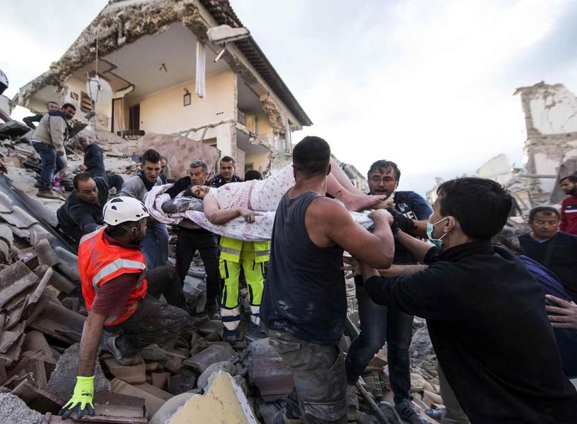 Miembros de la Protección Civil, el Cuerpo de Bomberos y el Ejercito italiano excavan en los edificios derrumbados. (AP)
