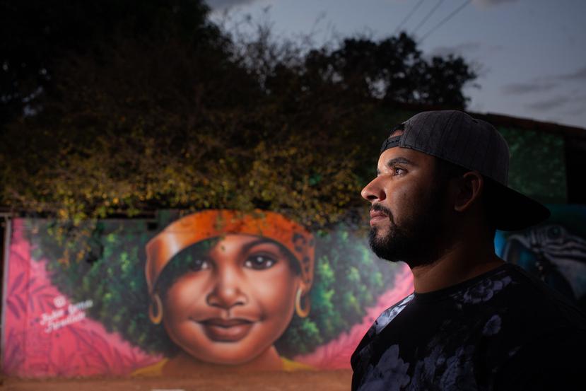 El artista del grafiti Fábio da Costa Gomes posa para una foto junto a uno de sus murales, el 18 de septiembre de 2020 en Trindade, Goiás, Brasil.