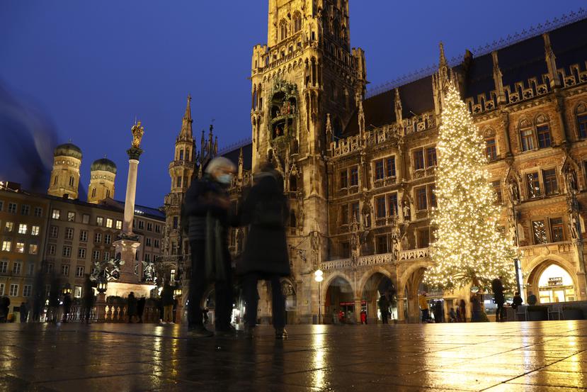 Gente con mascarilla ante un gran árbol de Navidad en la famosa Marienplatz en Múnich, Alemania.