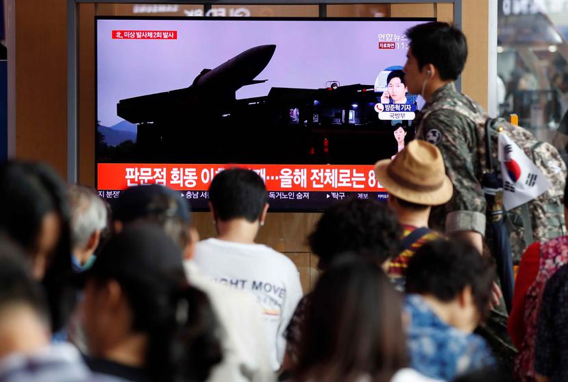 Un grupo de surcoreanos ve este viernes, en la pantalla de un comercio, las últimas noticias sobre los proyectiles de corto alcance que ha lanzado Corea del Norte. (Agencia EFE)