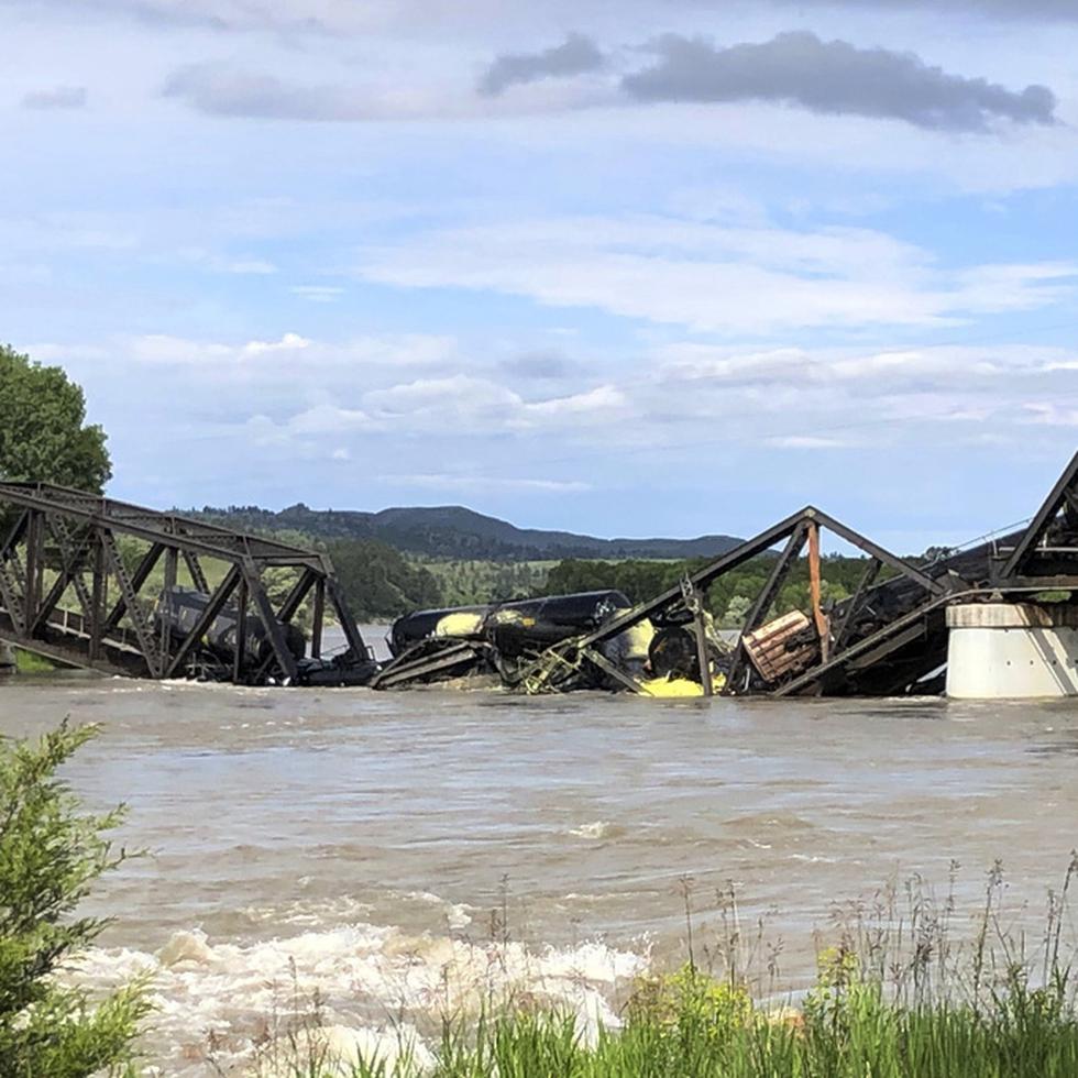 Varios vagones de un tren de carga están semisumergidos en el río Yellowstone tras el derrumbe de un puente cerca de Columbus, Montana, sábado 24 de junio de 2023.  (AP Foto/Matthew Brown)