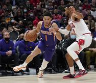 Devin Booker, de los Suns de Phoenix, va hacia la canasta mientras Troy Brown Jr., de los Bulls de Chicago, defiende durante la segunda mitad del partido del lunes.