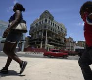 Algunos peatones caminan frente al Hotel Saratoga, dañado por una explosión, en La Habana, Cuba.