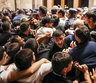 Manifestantes se enfrentan a la policía en un edificio gubernamental de Armenia durante una protesta en contra del primer ministro Nikol Pashinián.