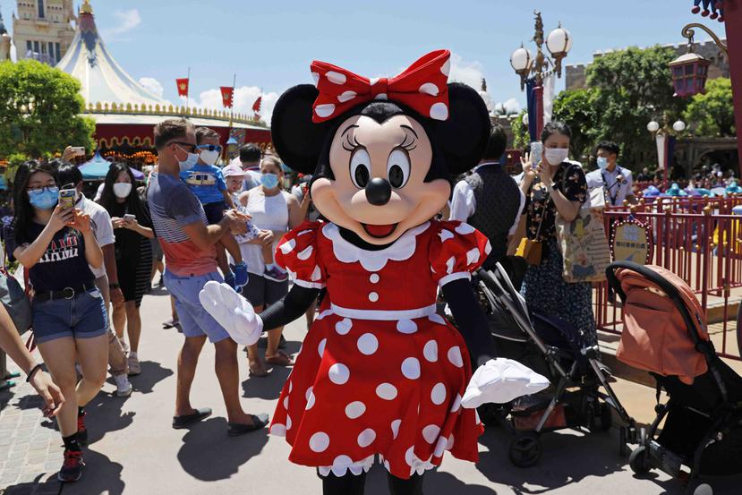 El icónico personaje de Minnie Mouse saluda a los visitantes en el parque Disneyland de Hong Kong en su reapertura en casi cinco meses por la crisis del coronavirus, el 18 de junio de 2020. (AP Foto/Kin Cheung)