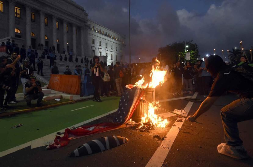 Manifestantes queman bandera de Estados Unidos.