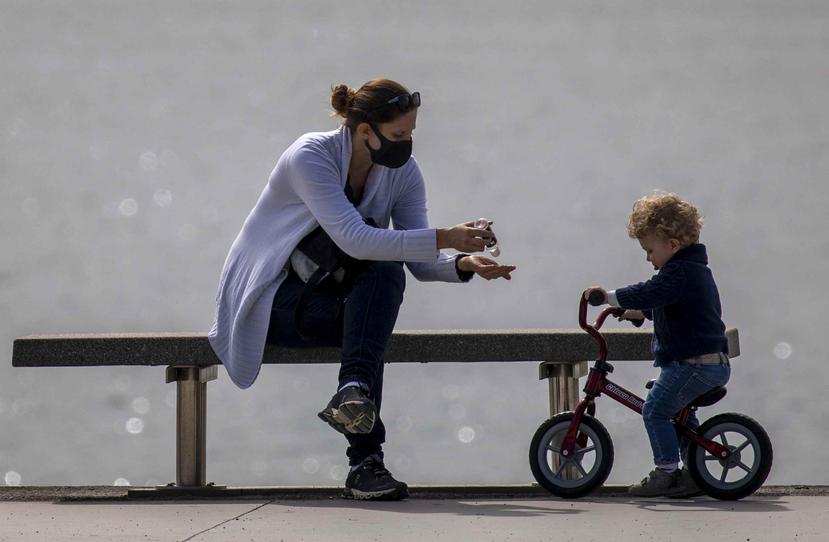 Una madre utiliza desinfectante de manos para ella y su hijo en Barcelona, España. (AP)