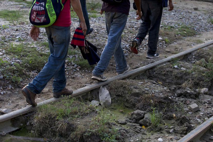 Un grupo reducido de migrantes hondureños que intenta llegar a la frontera de Estados Unidos camina por una vía del tren en Trancas Viejas, estado de Veracruz. (AP Foto/Rebecca Blackwell)