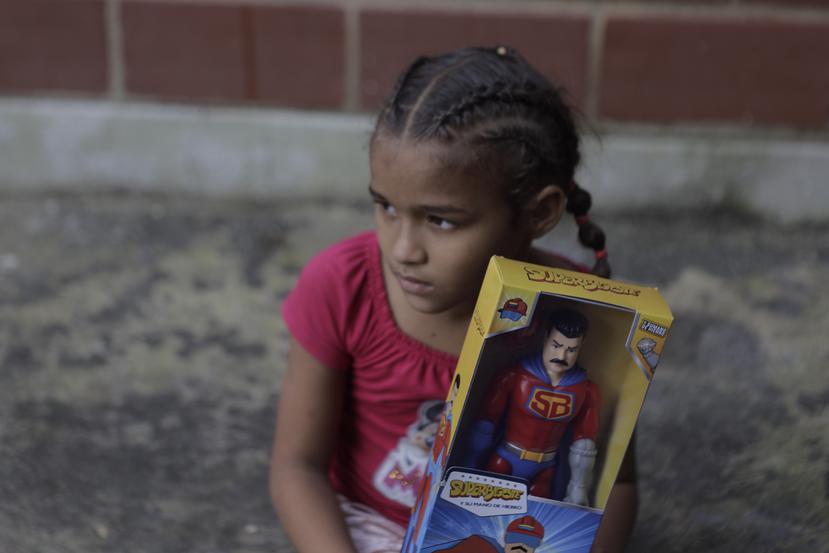 Una niña con su muñeco de Super Bigote en el vecindario Carayaca de La Guaira, Venezuela.