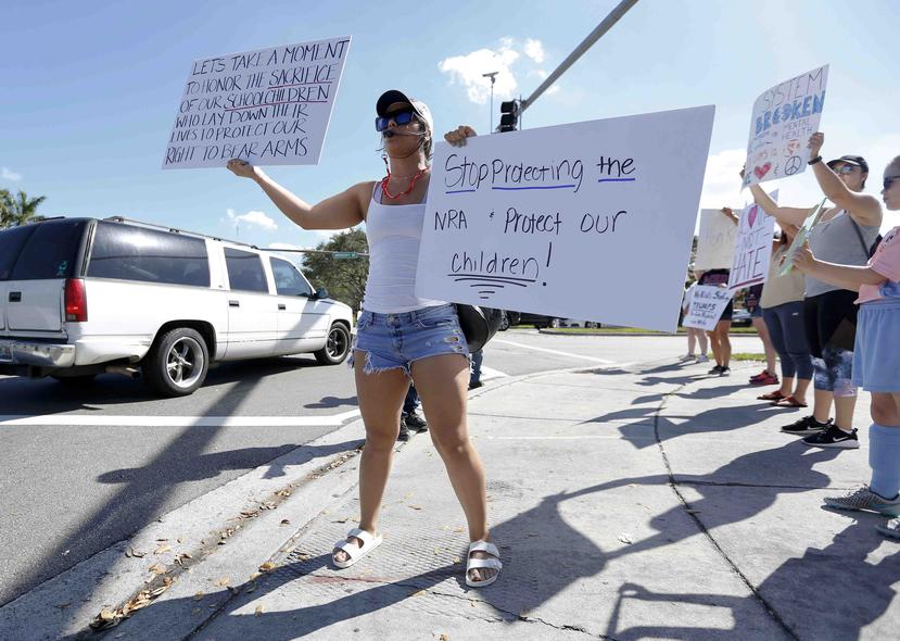 Juliana Cruz protesta con letreros en contra de las armas en Parkland, Florida. (AP)