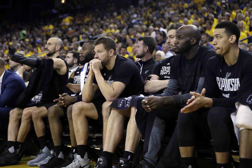 Jugadores de los Spurs de San Antonio parecen mostrar su frustración en la banca durante el desarrollo del segundo partido de la serie final de la Conferencia Oeste ante los Warriors de Golden State. (AP / Marcio José Sánchez)