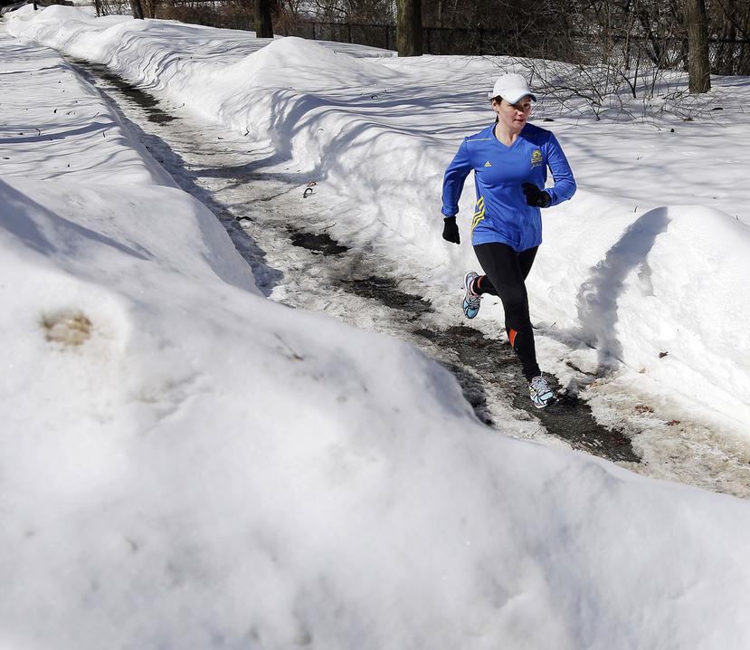 Becca Pizzi corre por una vereda rodeada de varios pies de nieve. (The Associated Press)