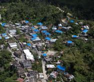 Foto de archivo de una vista de varias casas con toldos azules tras el paso del huracán María.