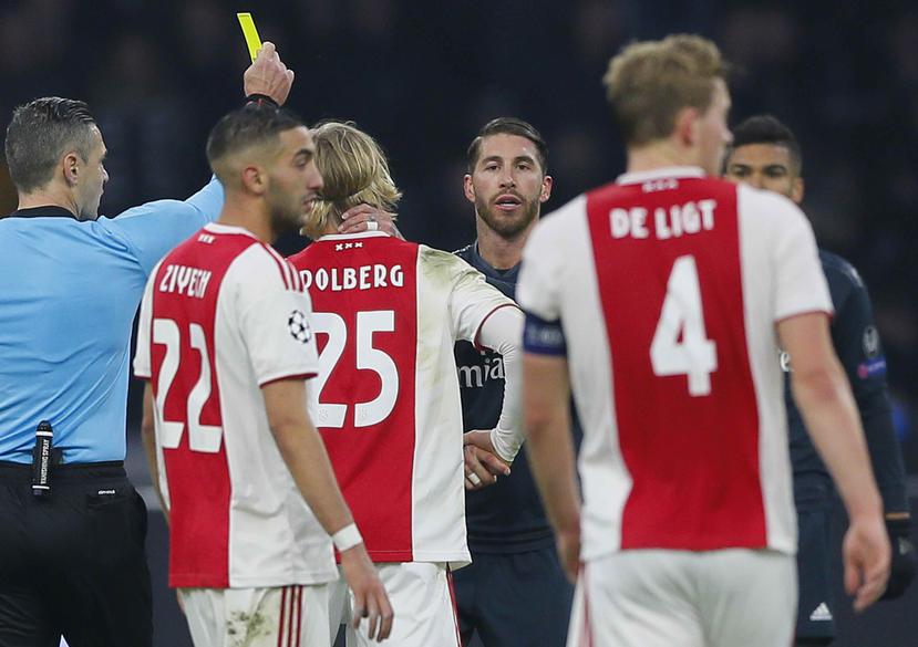 El árbitro Damir Skomina (izquierda), imponiendo una tarjeta amarilla al jugador del Real Madrid Sergio Ramos (al centro). (AP)