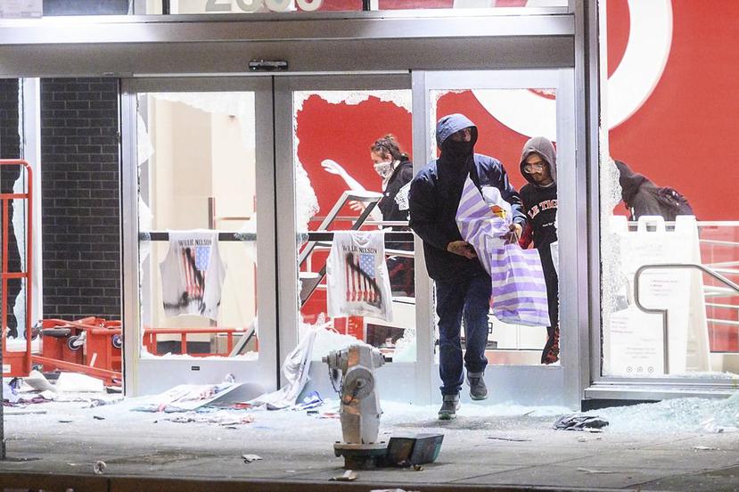 La gente sale de una tienda Target destrozada en Oakland, California durante las protestas contra el asesinato de George Floyd. (AP)