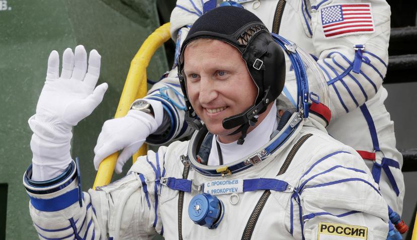 El astronauta ruso Sergey Prokopyev saluda al abordar una nave espacial en una misión rumbo a la Estación Espacial Internacional. (AP)