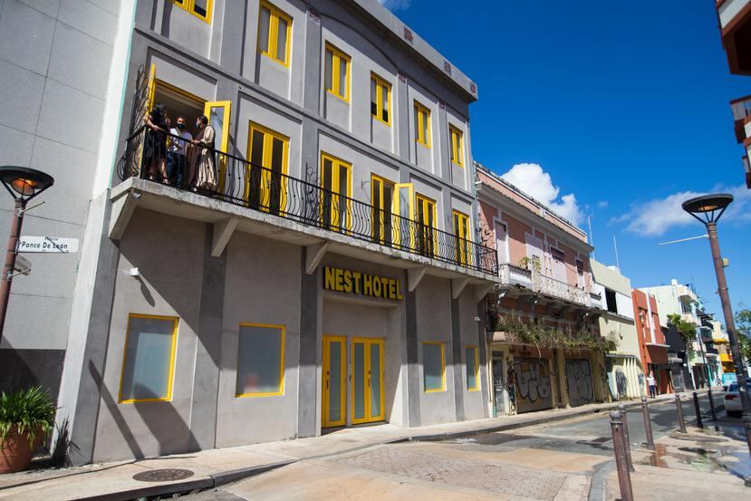 La fachada principal de Nest Hotel se caracteriza por sus ventanas y puertas amarillas.