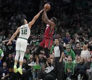 El delantero del Heat de Miami, Jimmy Butler, se suspende en el aire y tira al canasto ante la defensa de Grant Williams (12), de los Celtics de Boston.