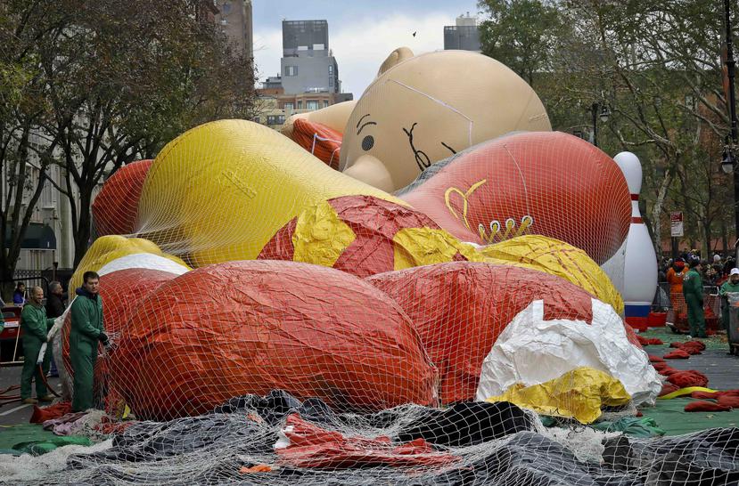 Operarios inflan globos gigantes, incluyendo uno con la imagen de Charlie Brown, en la víspera de su participación en la 92da edición del Desfile del Día de Gracias de Macy’s, el 21 de noviembre de 2018, en Nueva York. (AP)