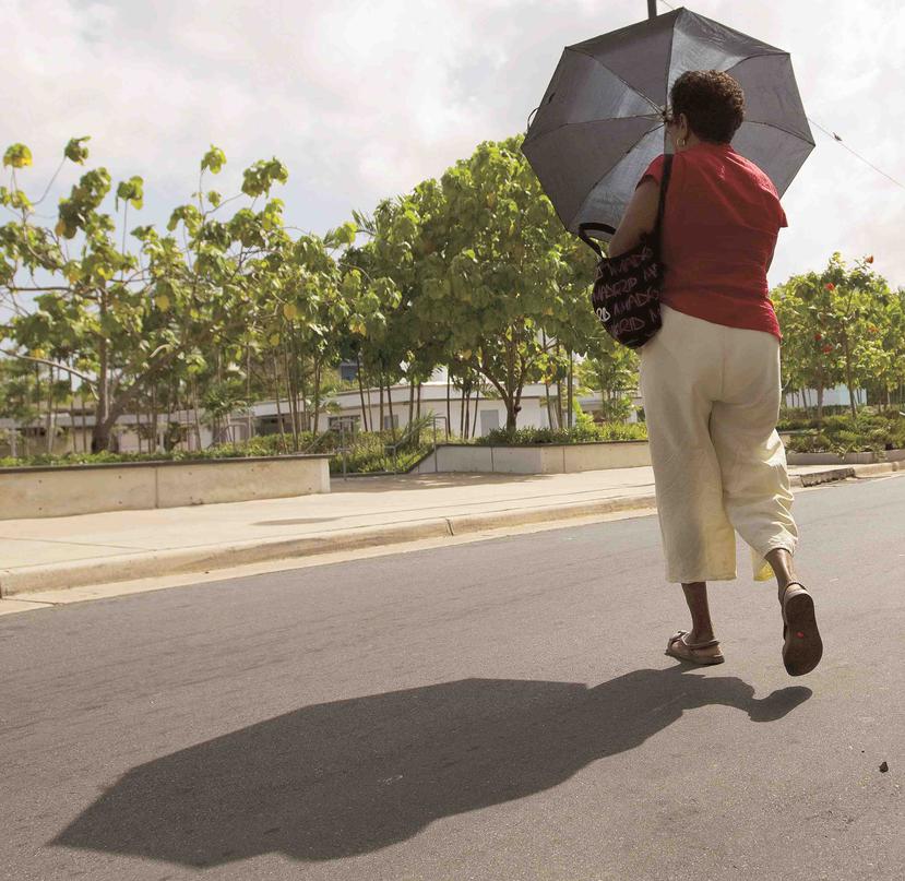 Una mujer se protege con una sombrilla del sol. (Archivo / GFR Media)