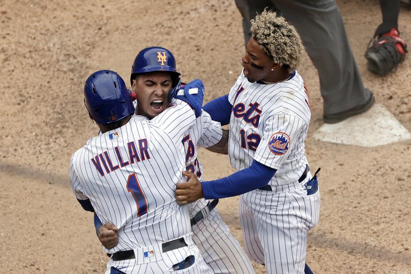 Javier Báez celebra con Jonathan Villar y su compatriota Francisco Lindor luego de anotar la carrera que le dio la victoria a los Mets de Nueva York en la novena ante Miami.