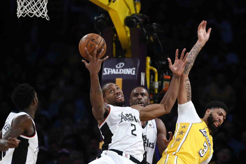 Kawhi Leonard, de los Clippers de Los Ángeles captura el balón pese a la defensa de Anthony Davis, de los Lakers. (AP / Ringo H.W. Chiu)