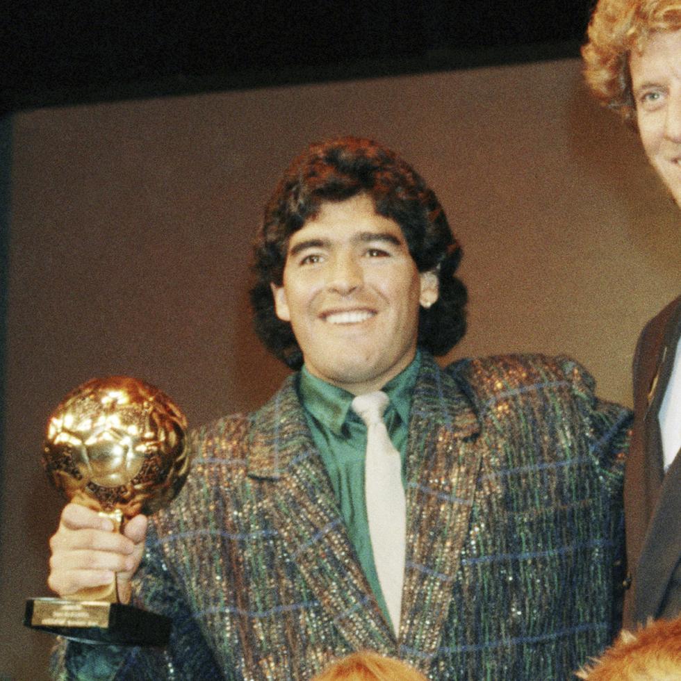 La estrella argentina Diego Maradona (izquierda) y el portero de Alemania Occidental Harald Schumacher sostienen sus trofeos de la Copa Mundial de Fútbol durante la ceremonia del Premio de la Bota de Oro de Fútbol celebrada en París, Francia, el 13 de noviembre de 1986.