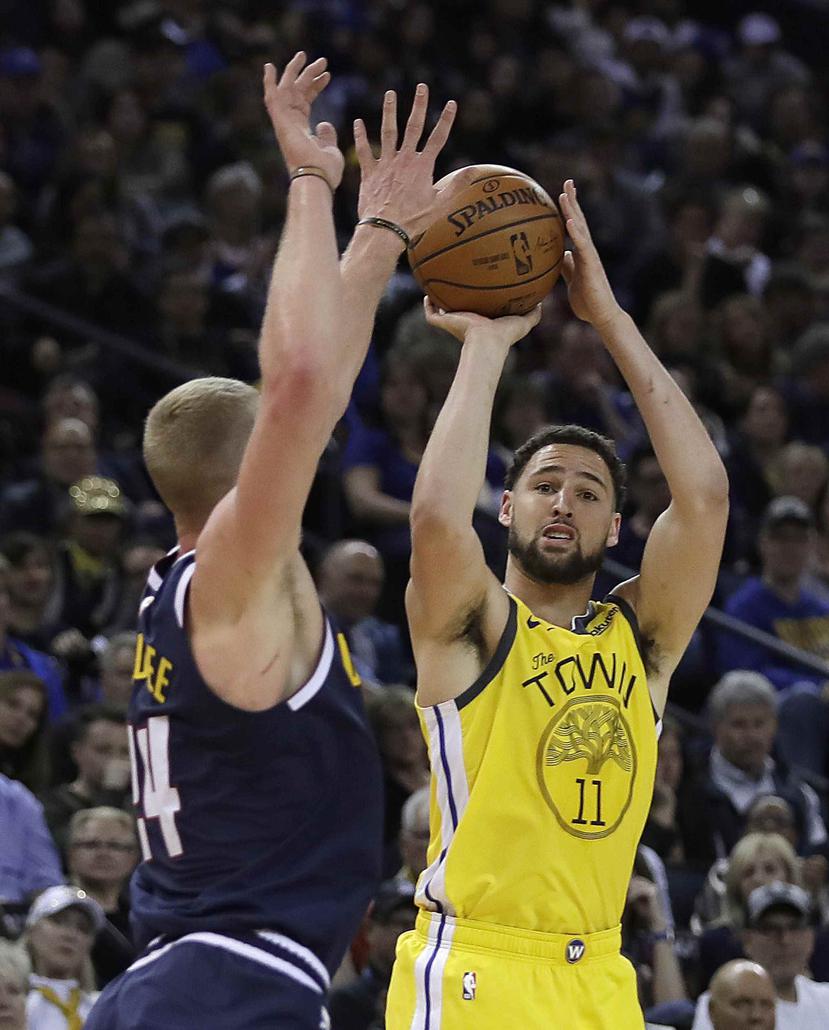 Klay Thompson, de los Warriors de Golden State, trata de encestar frente a Mason Plumlee de los Nuggets de Denver, en el partido de la NBA el viernes 8 de marzo de 2019, en Oakland, California (AP/Ben Margot)