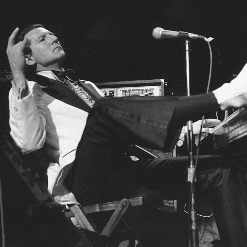Jerry Lee Lewis coloca un pie sobre las teclas del piano durante una presentación en el Madison Square Garden de Nueva York, el 14 de marzo de 1975.