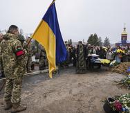 Soldados ucranianos asisten al entierro de su compañero Georgiy Plisak, asesinado por las fuerzas rusas, en un cementerio cerca de Lutsk, en Ucrania, el 31 de marzo de 2022. (AP Foto/Evgeniy Maloletka)