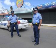 Dos policías patrullan los kioskos de Luquillo para asegurarse que se cumple con el toque de queda. (GFR Media / Gerald López Cepero)