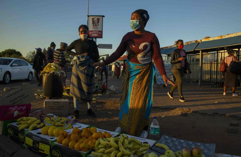 Vendedoras callejeras, luciendo máscaras protectoras para el coronavirus, venden frutas en una esquina en Katlehong, al este de Johanesburgo, Sudáfrica. el 6 de mayo del 2020. (AP Foto/Themba Hadebe)

