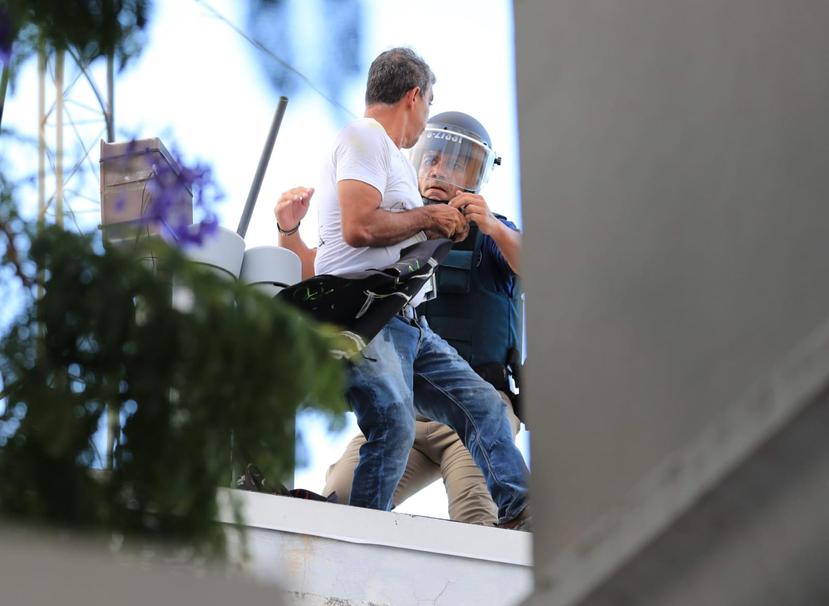 La foto muestra el momento en que un agente de la Policía pone bajo arresto a Alberto de Jesús Mercado, conocido como “Tito Kayak”.
