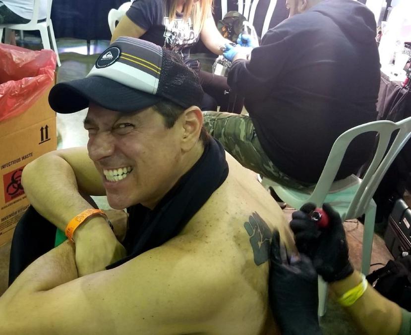La foto muestra el momento en que retocaron el tatuaje de Juan Dalmau en la actividad en el Centro de Convenciones de Puerto Rico en Miramar.  (Twitter.com / Juan Dalmau)
