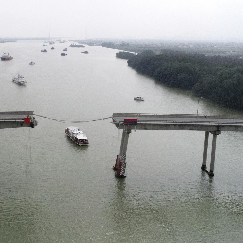 Un barco pasa por debajo del destrozado puente de Lixinsha, en el distrito de Nansha en Guangzhou, en la provincia de Guangdong, en el sur de China, luego que un barco contenedor chocara contra la estructura.